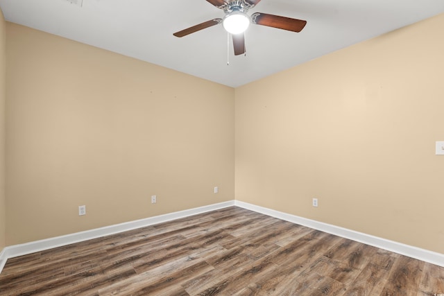 empty room with a ceiling fan, baseboards, and wood finished floors