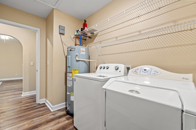 washroom with arched walkways, electric water heater, laundry area, separate washer and dryer, and wood finished floors