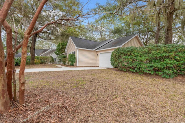 view of side of home with a garage and driveway