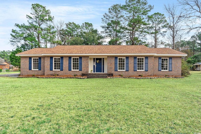 ranch-style house with a shingled roof, crawl space, brick siding, and a front lawn