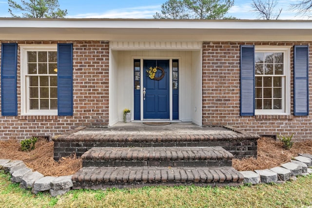 doorway to property featuring brick siding