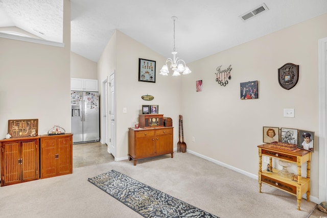 interior space with baseboards, visible vents, light colored carpet, lofted ceiling, and a notable chandelier