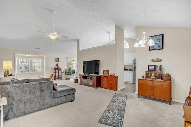 living room featuring visible vents, light carpet, a textured ceiling, and ceiling fan with notable chandelier