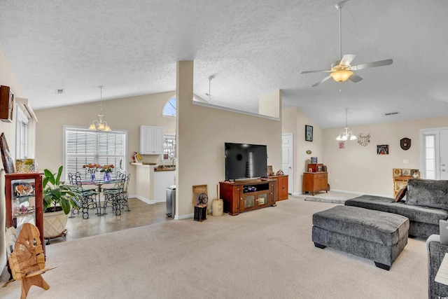 living area with a healthy amount of sunlight, vaulted ceiling, light carpet, and a textured ceiling