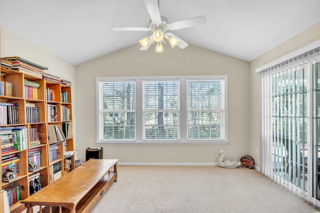 sitting room featuring a textured ceiling, ceiling fan, carpet floors, baseboards, and vaulted ceiling