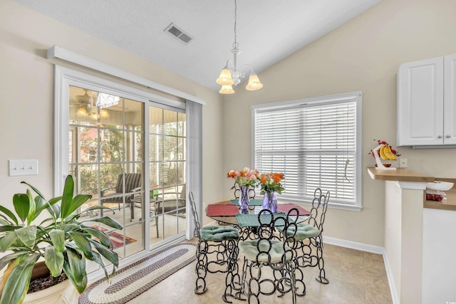 dining space featuring lofted ceiling, an inviting chandelier, visible vents, and a wealth of natural light