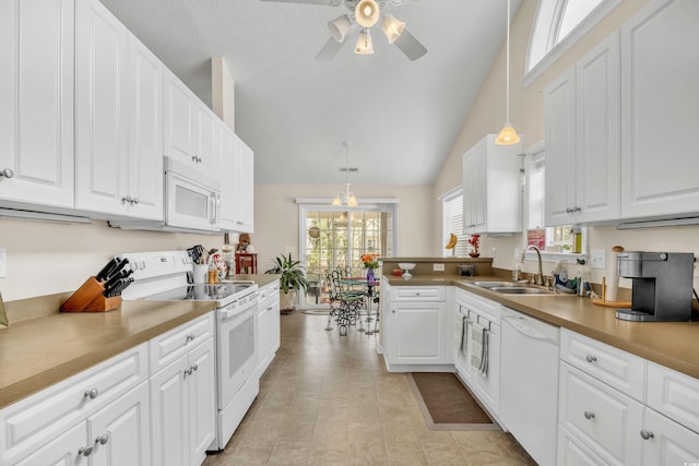 kitchen with white appliances, white cabinets, and a sink