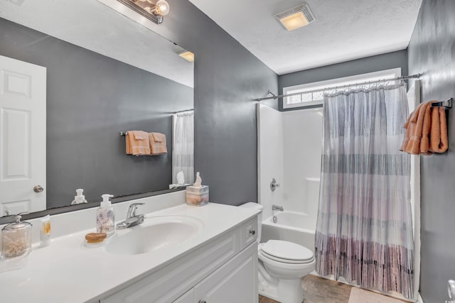 full bathroom with visible vents, toilet, shower / bath combo with shower curtain, vanity, and a textured ceiling