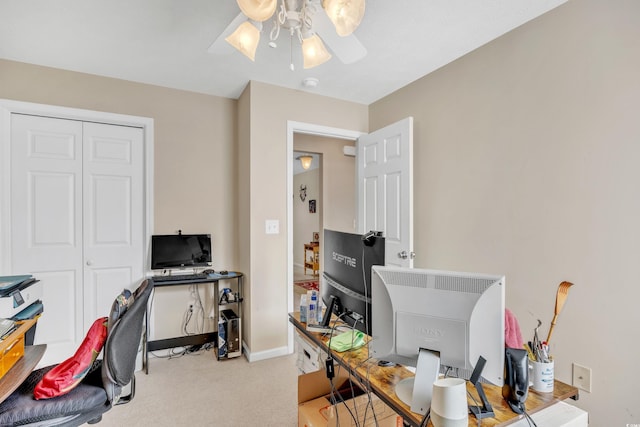 carpeted home office with baseboards and a ceiling fan