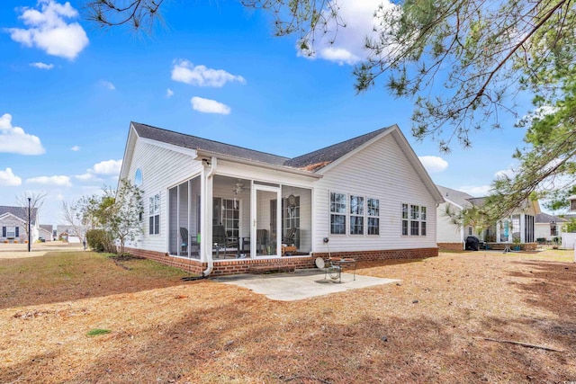 rear view of house featuring a sunroom and a patio