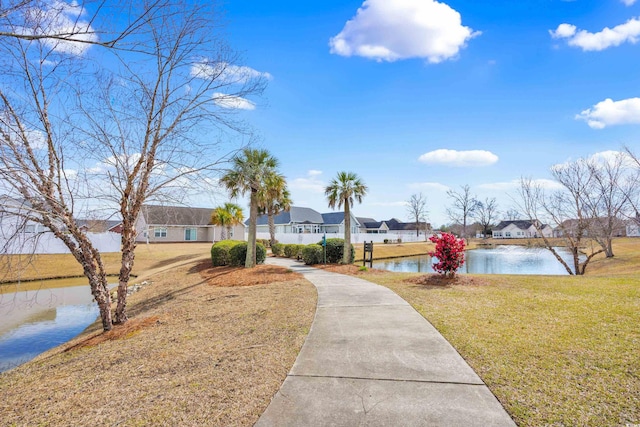 view of home's community featuring a lawn, a water view, and a residential view