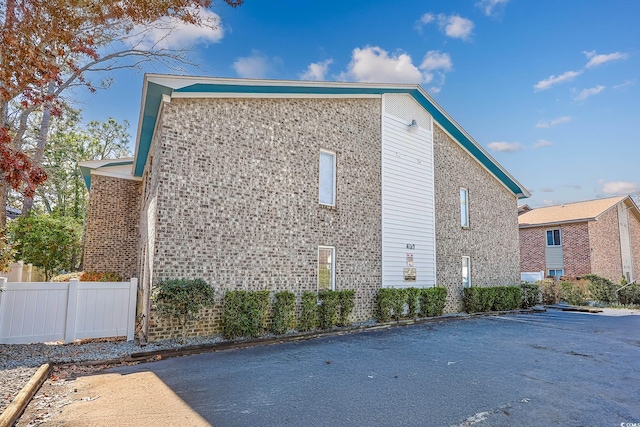 view of home's exterior with fence and brick siding