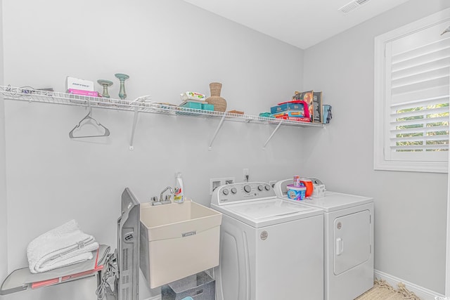 laundry room featuring visible vents, a sink, laundry area, independent washer and dryer, and baseboards