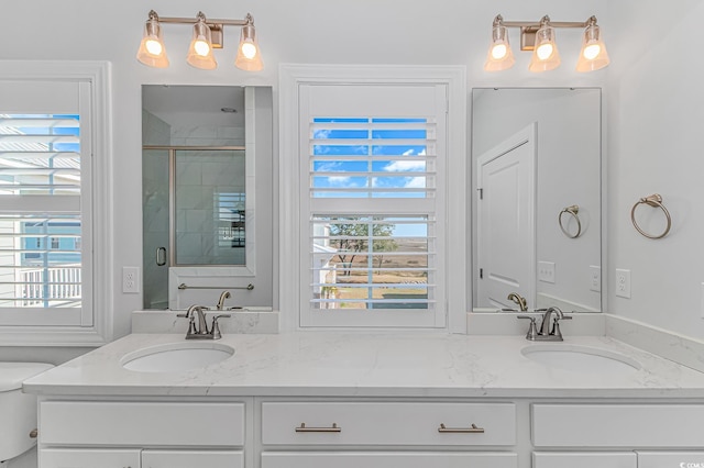 bathroom with plenty of natural light, a sink, and a shower stall