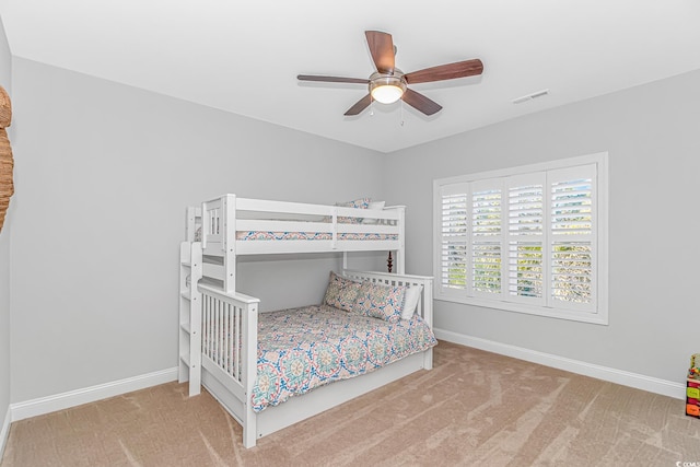 carpeted bedroom featuring visible vents, baseboards, and ceiling fan