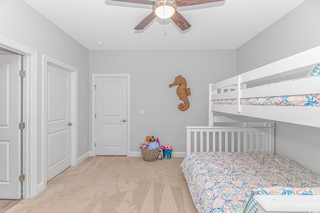 carpeted bedroom featuring baseboards and a ceiling fan