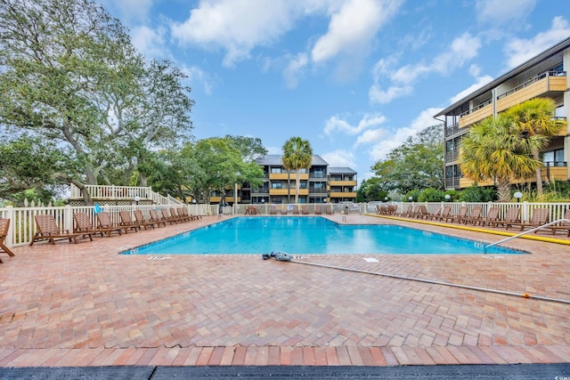 pool with a patio and fence