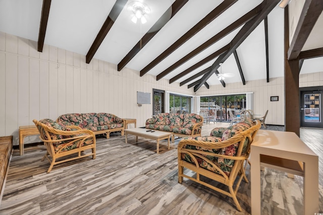 living area featuring lofted ceiling with beams, ceiling fan, and wood finished floors