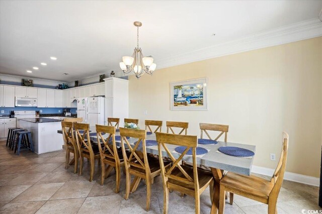 817 S Ocean Blvd Unit 105, North Myrtle Beach, SC 29582 - dining space featuring ornamental molding, a chandelier, and baseboards