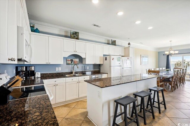 817 S Ocean Blvd Unit 105, North Myrtle Beach, SC 29582 - kitchen featuring a sink, white appliances, a center island, light tile patterned floors, and a kitchen breakfast bar