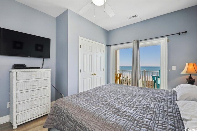 817 S Ocean Blvd Unit 105, North Myrtle Beach, SC 29582 - bedroom with access to exterior, a water view, wood finished floors, ceiling fan, and a closet