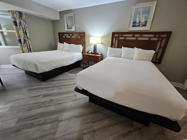 bedroom featuring baseboards and wood finished floors