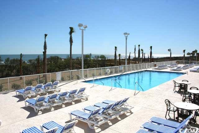 community pool with fence and a patio