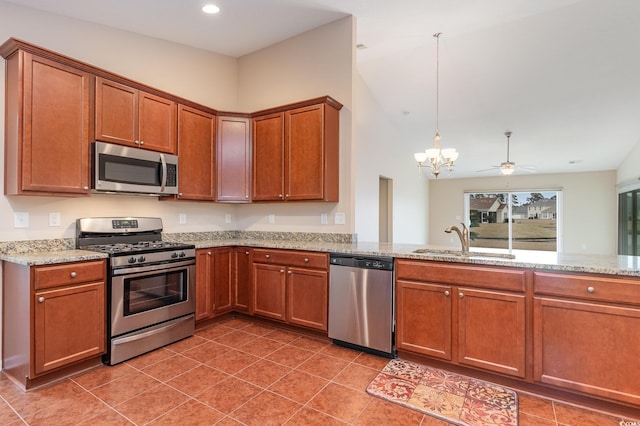 kitchen featuring appliances with stainless steel finishes, brown cabinetry, a sink, and light stone countertops