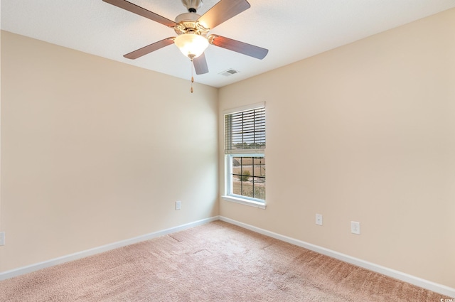 unfurnished room featuring baseboards, a ceiling fan, visible vents, and light colored carpet