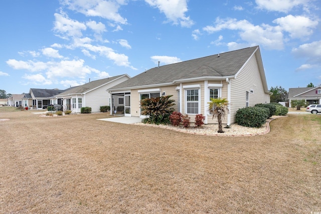 rear view of house with a residential view, a patio area, and a lawn