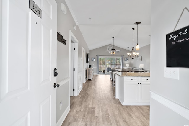 interior space with lofted ceiling, light wood-type flooring, and an inviting chandelier