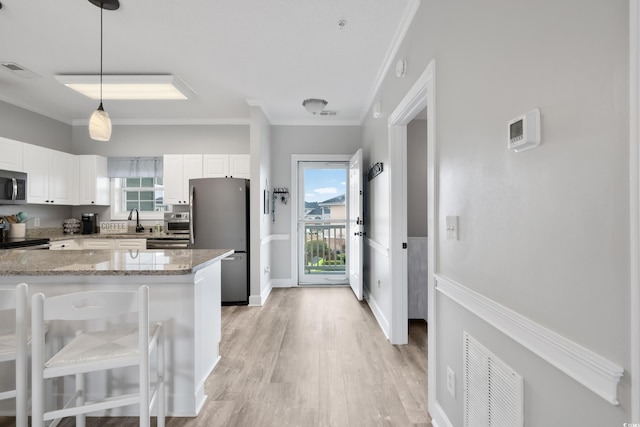 kitchen featuring light stone counters, visible vents, hanging light fixtures, appliances with stainless steel finishes, and white cabinetry