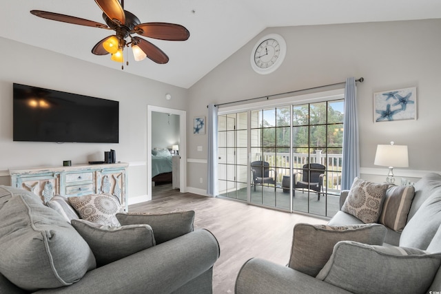 living room with a ceiling fan, vaulted ceiling, light wood-style flooring, and baseboards