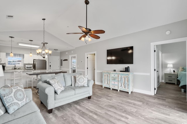 living room with vaulted ceiling, ceiling fan, visible vents, and light wood-style floors