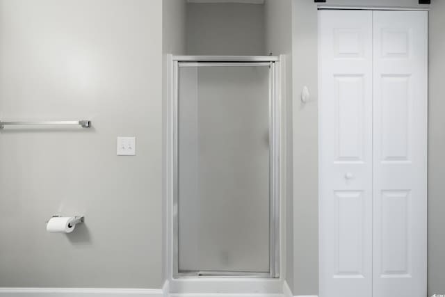 bathroom with a stall shower and a closet