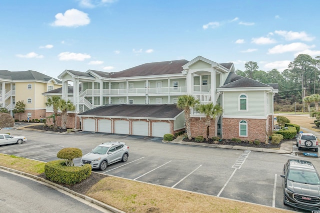 view of property with uncovered parking, a residential view, and community garages