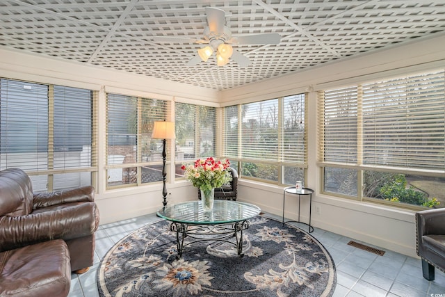 sunroom with tile patterned floors, visible vents, and baseboards