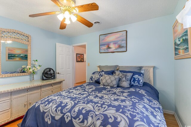 317 14th Ave N, Surfside Beach, SC 29575 - bedroom with light wood finished floors, a ceiling fan, and a textured ceiling