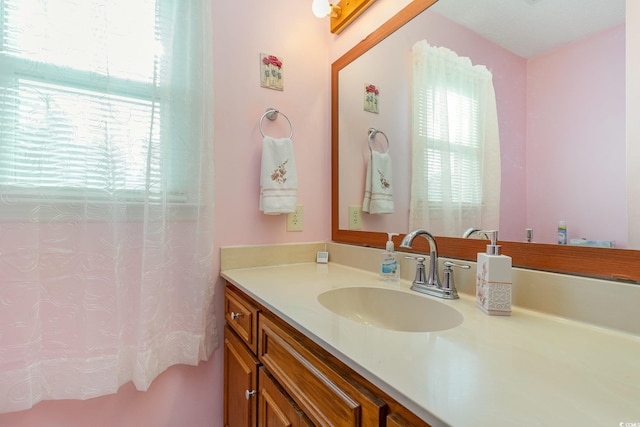 full bath with curtained shower, vanity, and a healthy amount of sunlight
