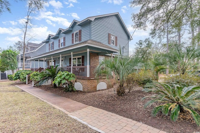 view of front facade featuring brick siding and covered porch