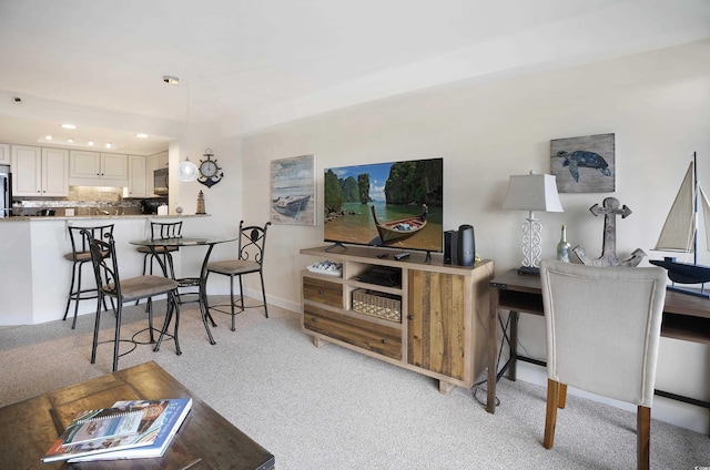 living room featuring recessed lighting, baseboards, and light colored carpet