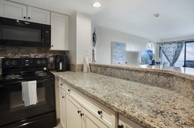 kitchen featuring black appliances, light stone counters, and hanging light fixtures