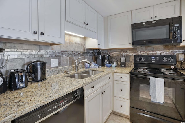 kitchen with black appliances, backsplash, white cabinets, and a sink