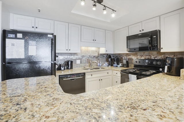 kitchen featuring a sink, white cabinets, backsplash, light stone countertops, and black appliances