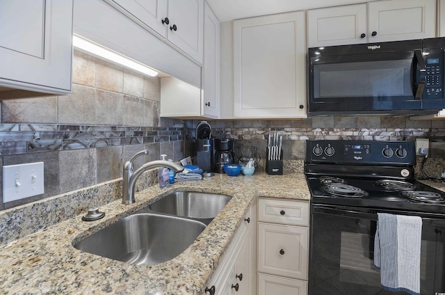 kitchen with decorative backsplash, white cabinets, a sink, and black appliances