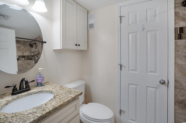 bathroom featuring toilet, visible vents, a shower, and vanity