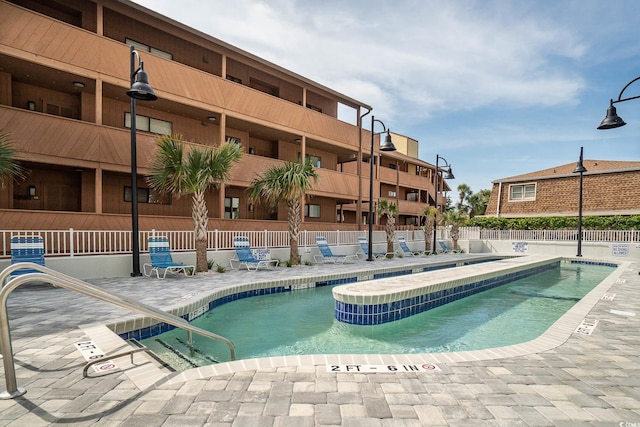 community pool featuring a patio area and fence