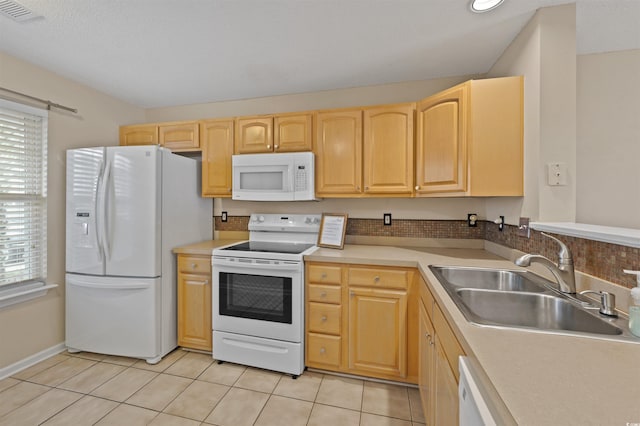 kitchen featuring light tile patterned floors, visible vents, light brown cabinets, a sink, and white appliances