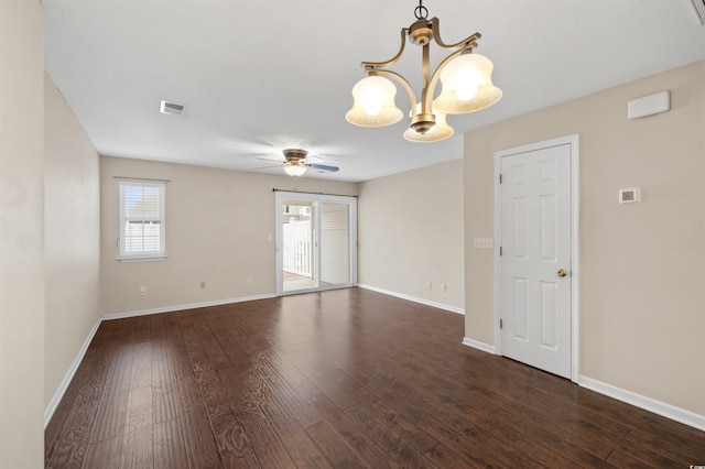 spare room with ceiling fan with notable chandelier, wood finished floors, visible vents, and baseboards