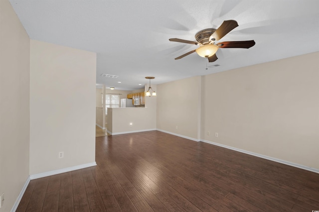 unfurnished living room with dark wood-style floors, ceiling fan, visible vents, and baseboards